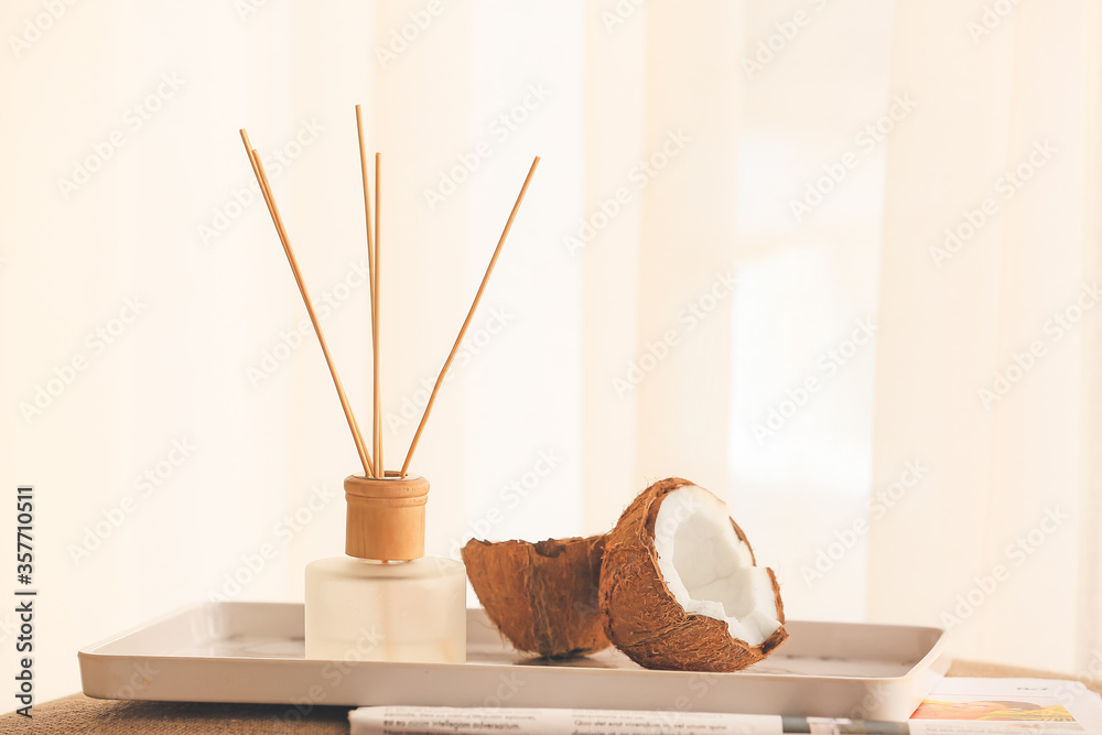 Reed diffuser and coconut on table in room