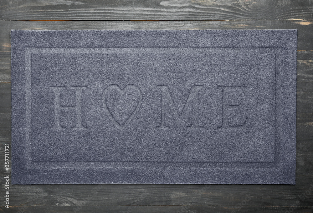 Door mat on wooden background