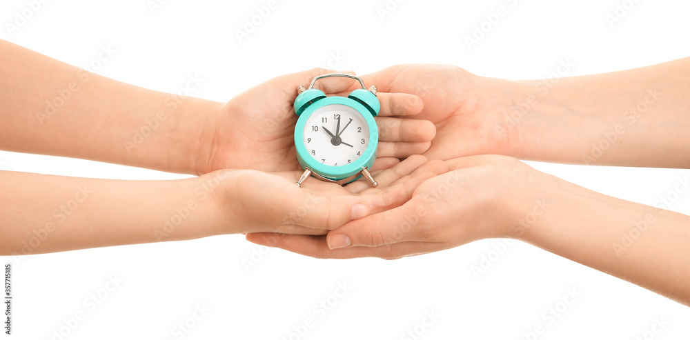 Hands of family with alarm clock on white background