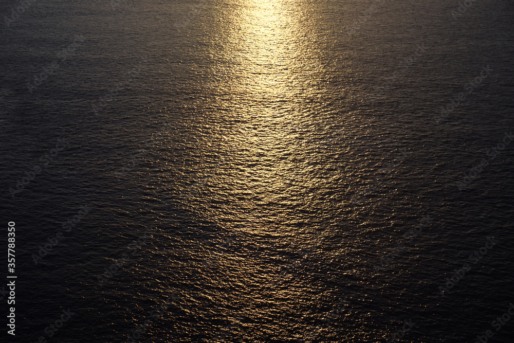 marvelous bright yellow sunlight reflected in calm endless ocean at sunset closeup