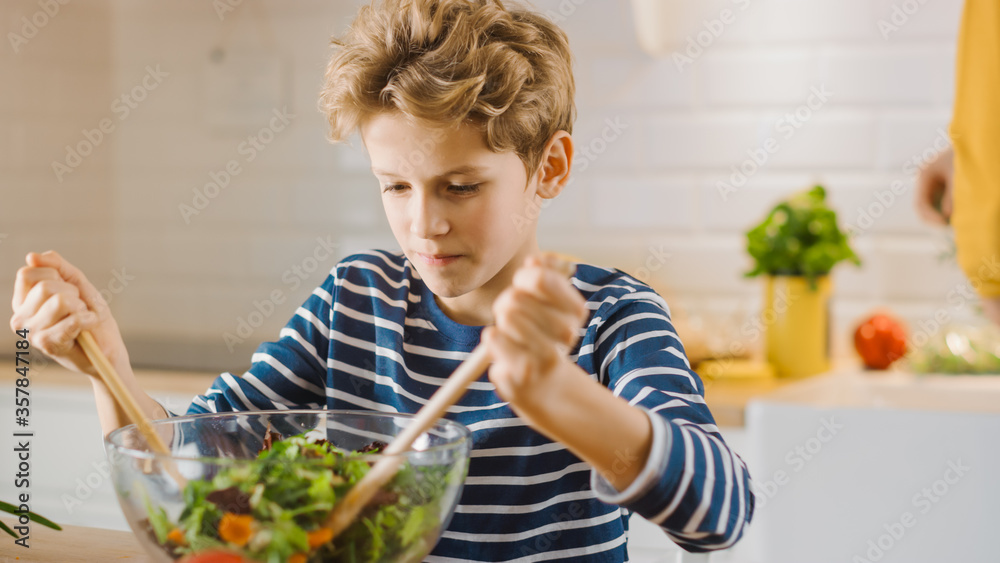 In Kitchen: Little Boy Cooking Together Healthy Dinner. Son Studies Healthy Habits and how to Mix Ve