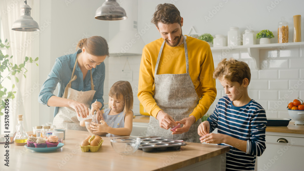 In the Kitchen: Family of Four Cooking Muffins Together. Mother and Daughter Mixing Flour and Water 