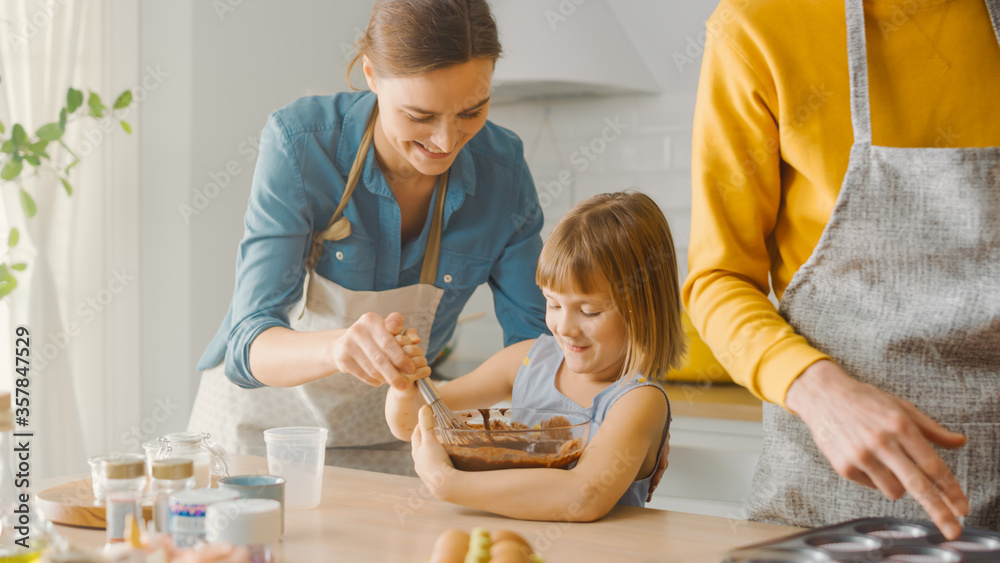 In the Kitchen: Family of Four Cooking Muffins Together. Mother and Daughter Mixing Flour and Water 