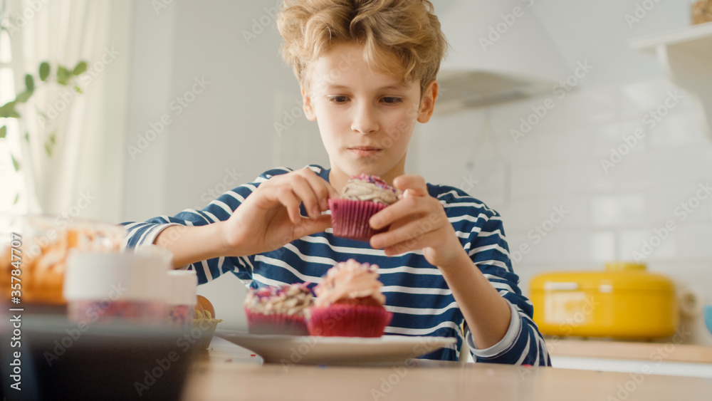 In the Kitchen: Adorable Boy Eats Creamy Cupcake with Frosting and Sprinkled Funfetti. Cute Hungry S