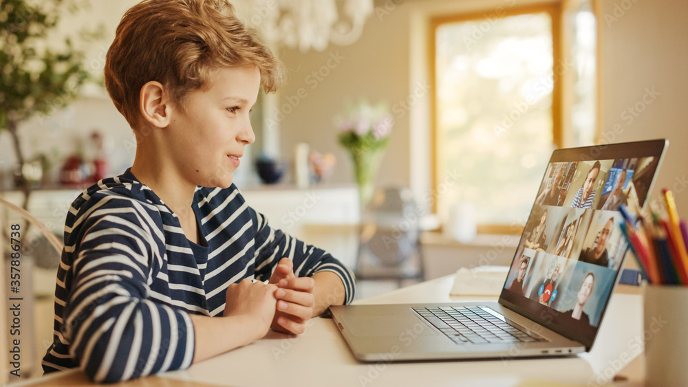 Cute Little Boy Uses Laptop with Conference Video Call Software to Talk with Group of Relatives and 