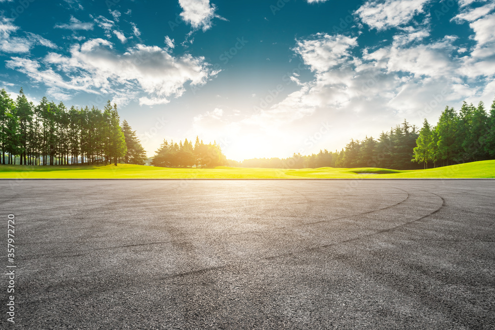 Empty asphalt road and green forest under blue sky.