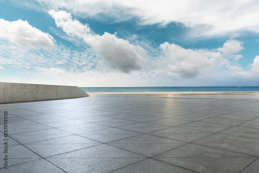 Empty square floor and lake under blue sky.