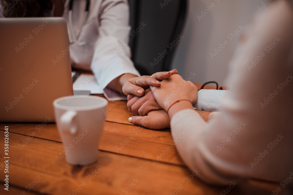 Close-up image of supporting hands of friendly general practitioner.