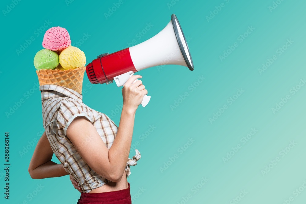 Beautiful woman with an ice-cream on the head holding megaphone and screams