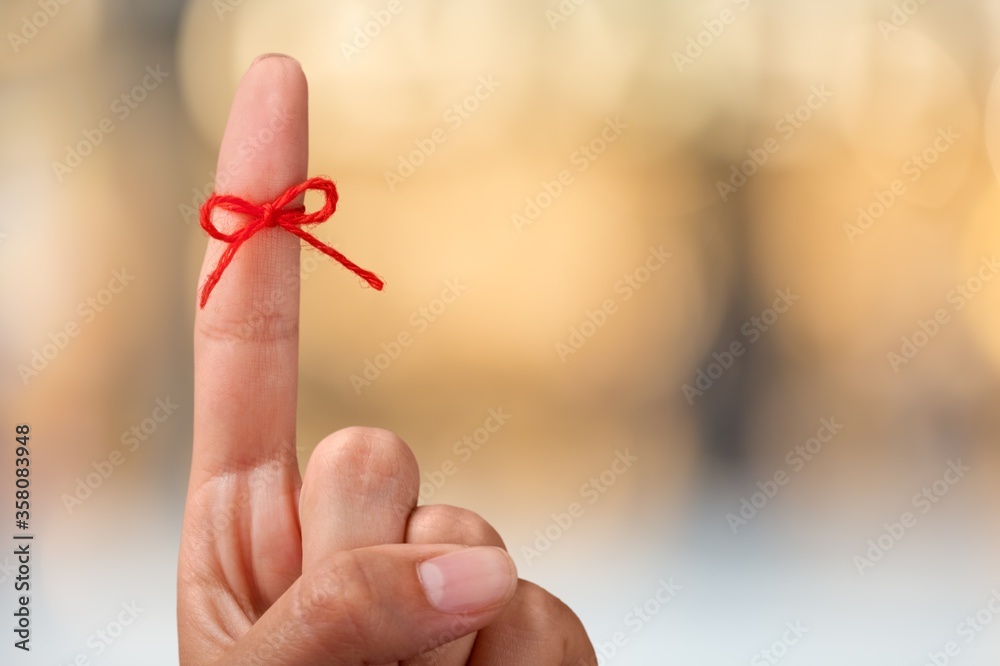 Red thread bow on a human finger