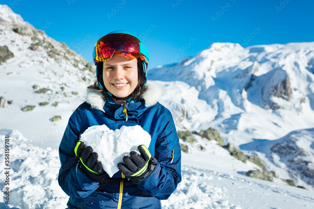 快乐的少女，穿着冬装，穿着滑雪服，戴着口罩，雪呈心形，描绘爱情莫