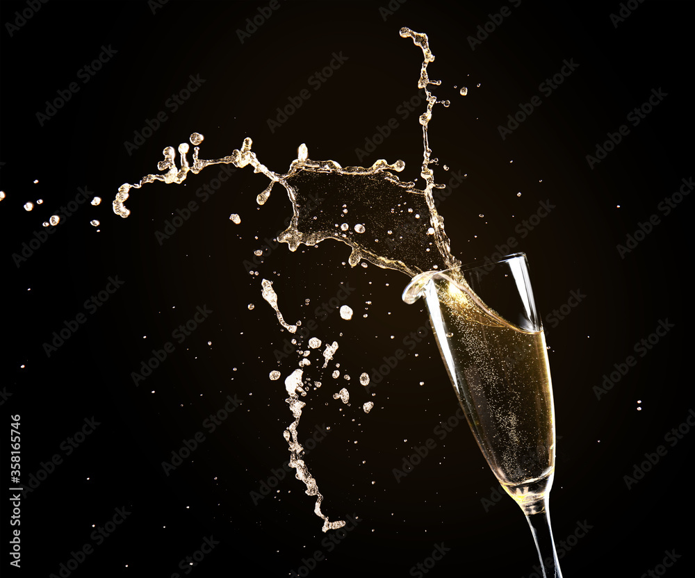 Glass of champagne with splash on dark background