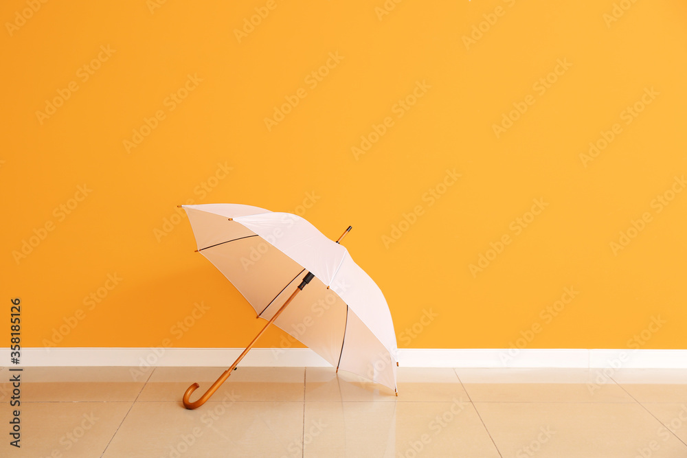 Stylish umbrella near color wall