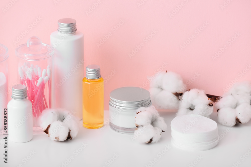 Cotton flowers with cosmetics and supplies on table