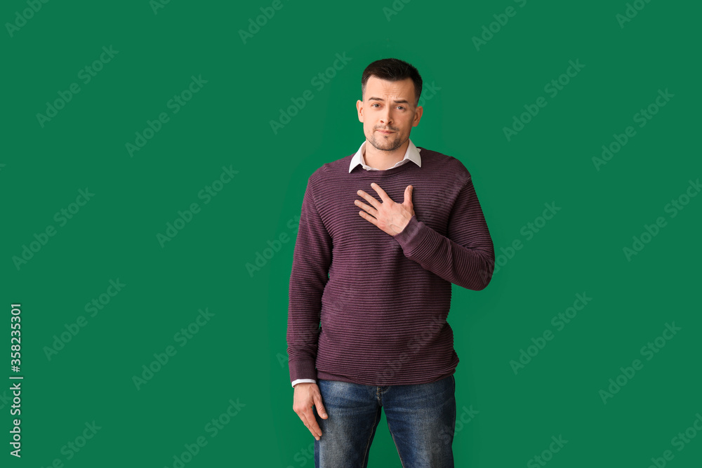 Portrait of apologizing man on color background