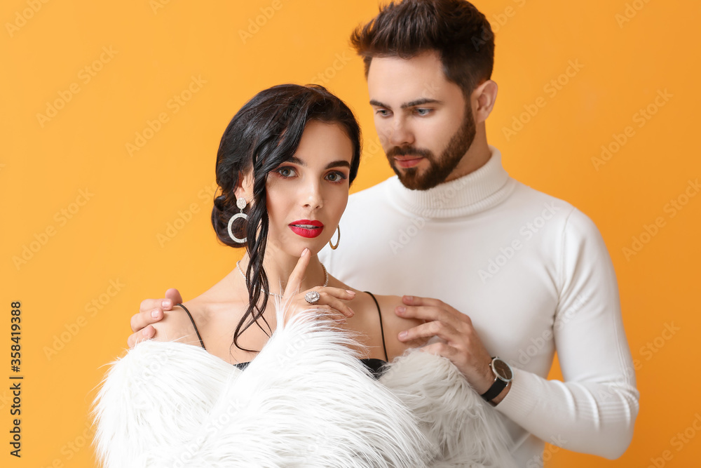 Young couple wearing stylish accessories on color background