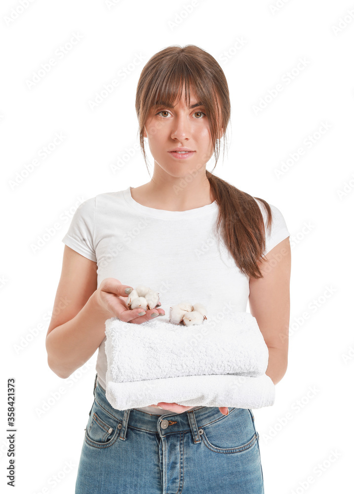 Beautiful young woman with cotton flowers and towels on white background