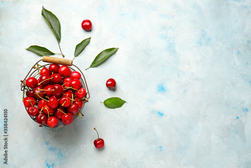 Basket with sweet cherry on color background