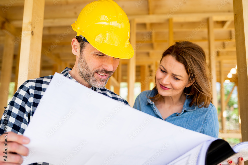 Female investor meeting with architect or engineer on construction site of her new house looking at 