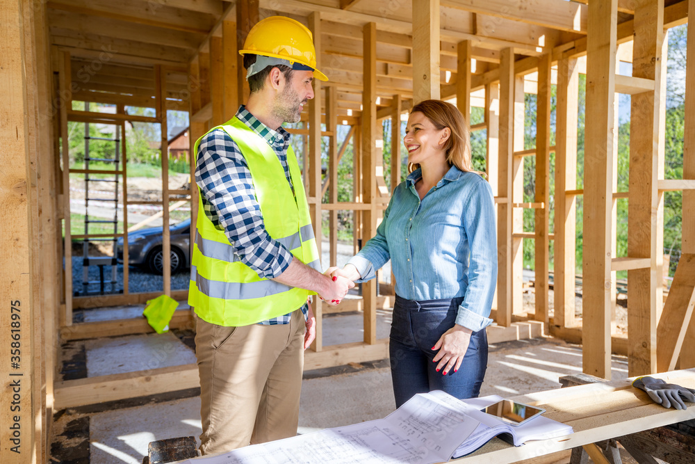 Engineer or architect on construction site of new house reach agreement with investor and home owner