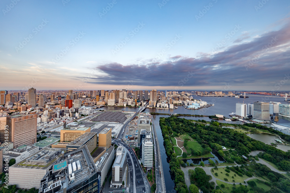 東京の水辺に建つビル群と夕焼けの空