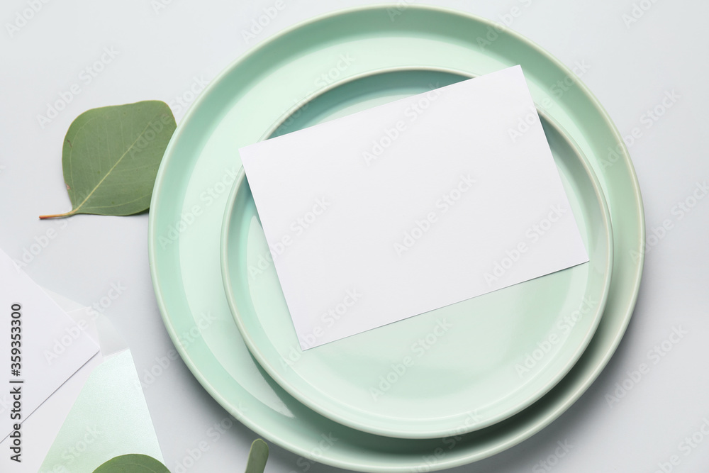 Plates with blank card on light background