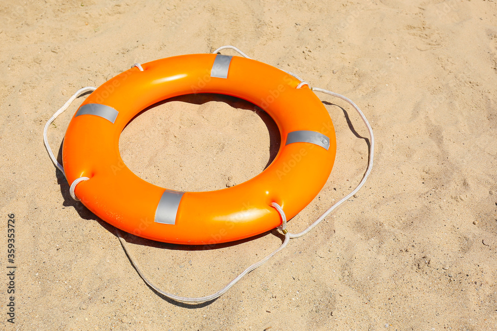 Bright lifebuoy ring on beach