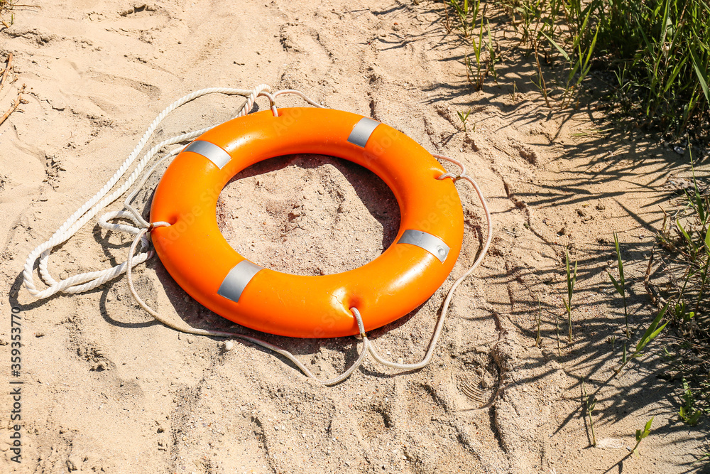 Bright lifebuoy ring on beach