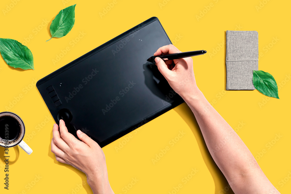 Person using a graphic pen tablet - flat lay