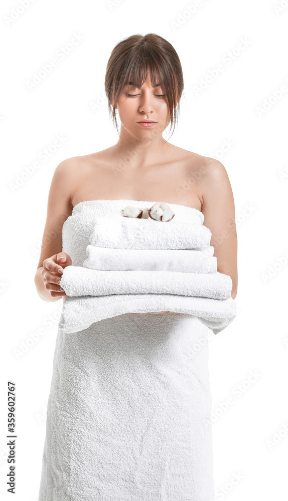 Beautiful young woman with cotton flowers and towels on white background