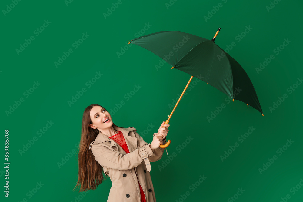 Beautiful woman with umbrella on color background