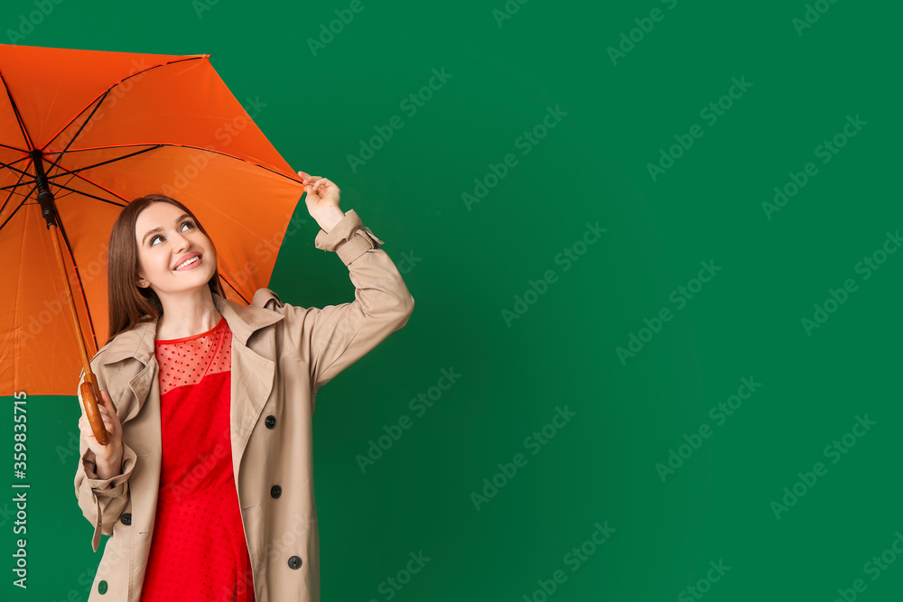 Beautiful woman with umbrella on color background