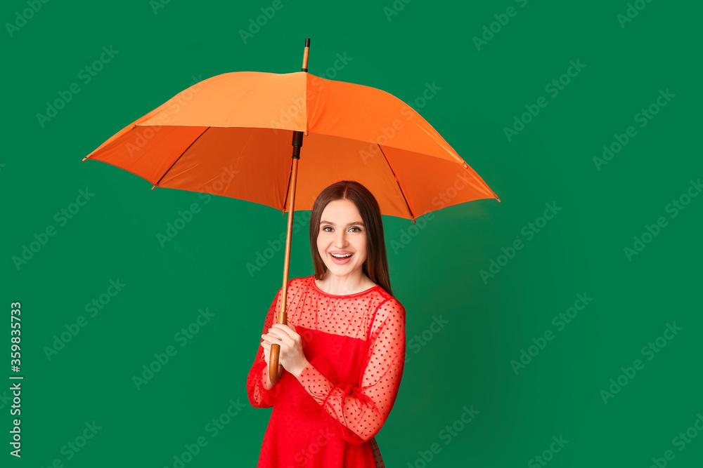 Beautiful woman with umbrella on color background