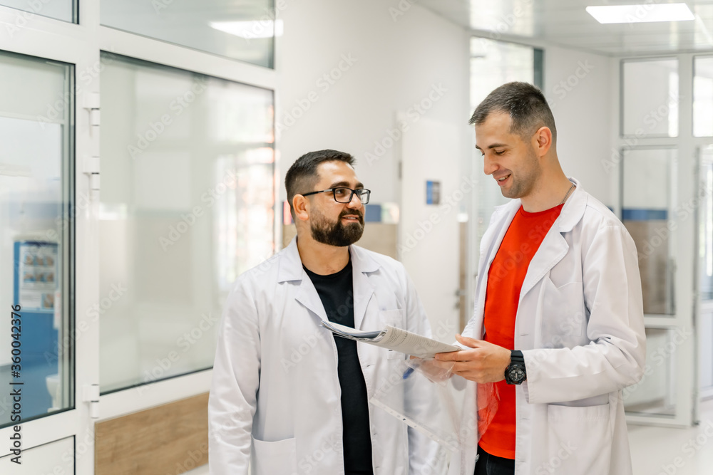 Portrait of male doctors with reports over white background.