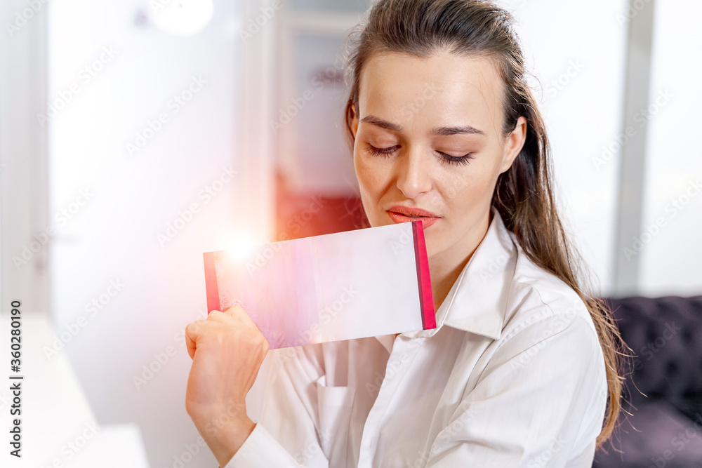 Girl with brochure at the reception. Customer in spa. Woman`s beauty concept.