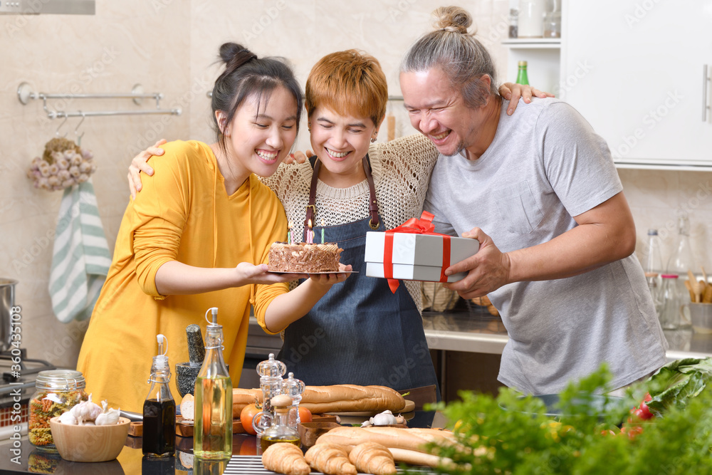 幸福的一家人在厨房里与蛋糕一起庆祝生日