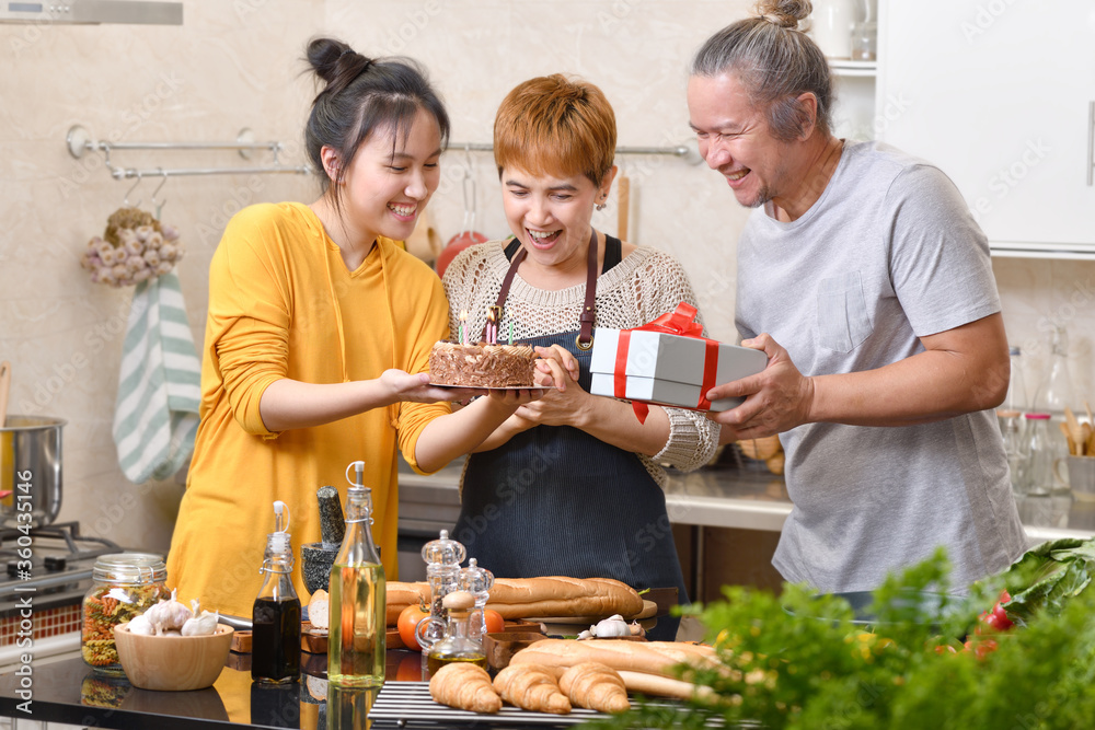 幸福的一家人在厨房里与蛋糕一起庆祝生日