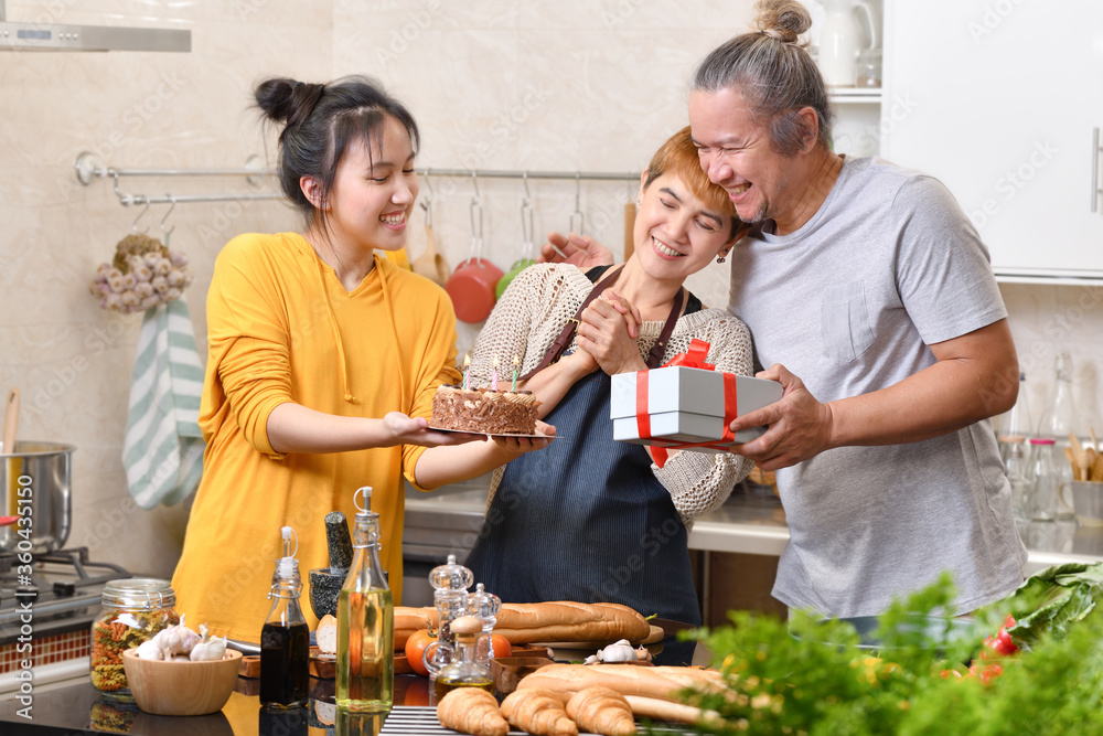 幸福的一家人在厨房里与蛋糕一起庆祝生日