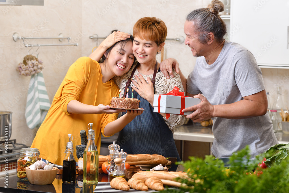 幸福的一家人在厨房里与蛋糕一起庆祝生日