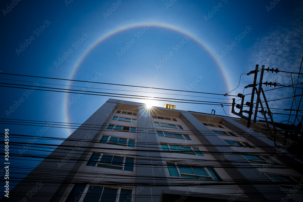 Amazing natural phenomena. Sun halo in Thailand or the sun with a rainbow on a tall building.