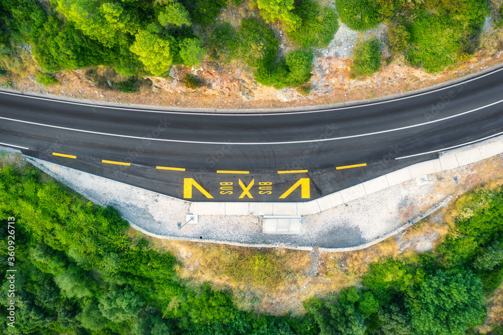 夏日日落时美丽的绿色森林中的道路鸟瞰图