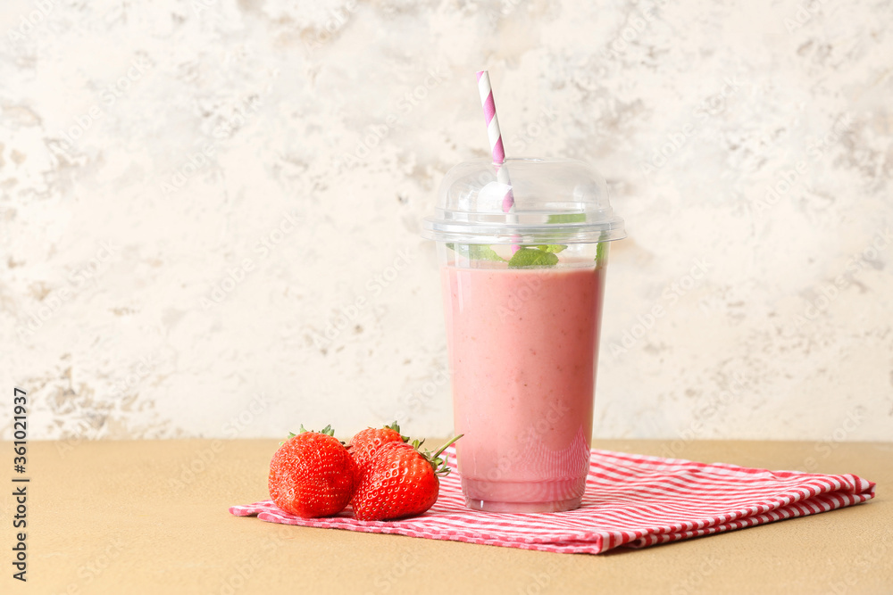 Cup of tasty strawberry smoothie on table