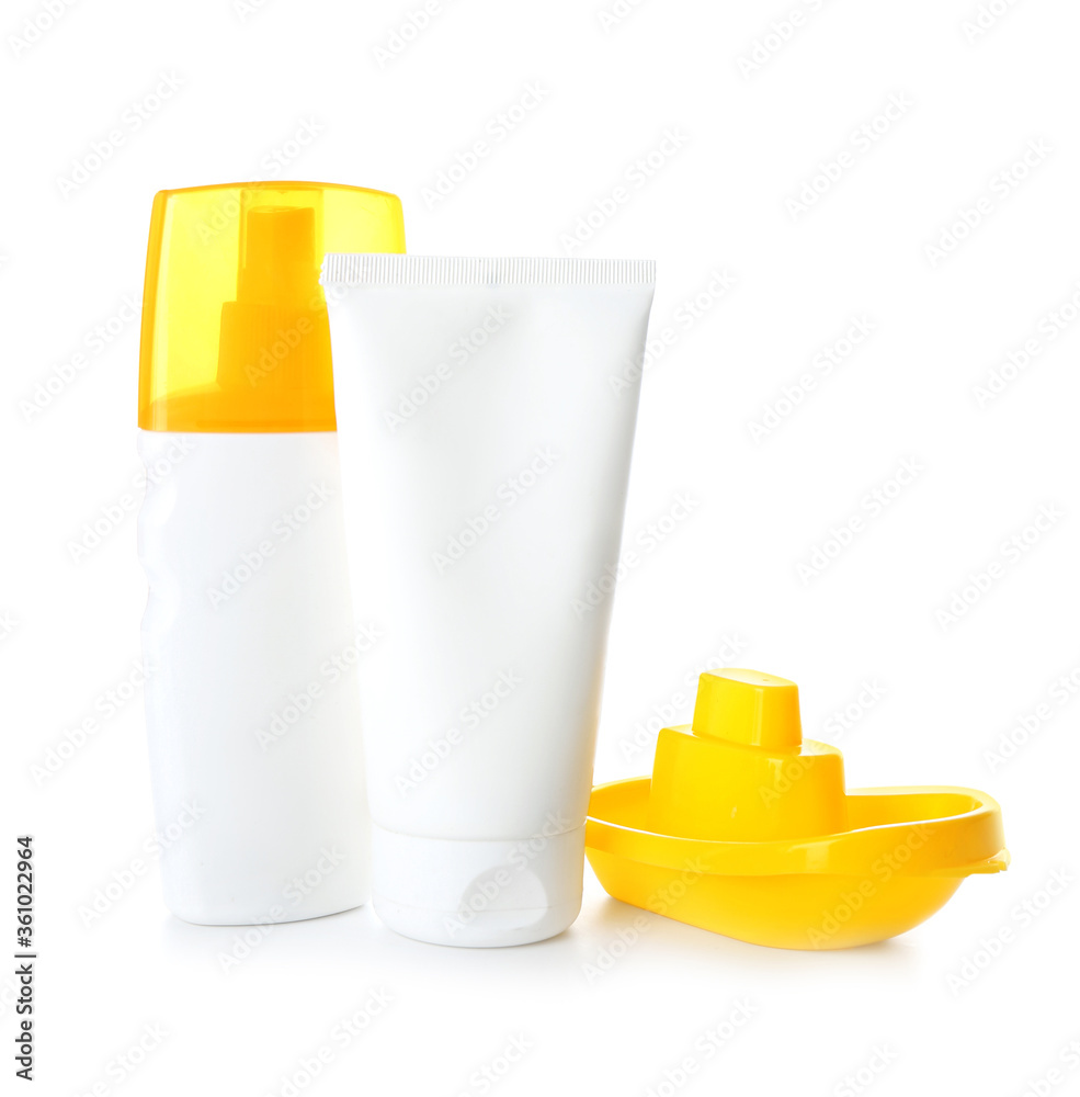 Sunscreen cream with beach sand toy on white background