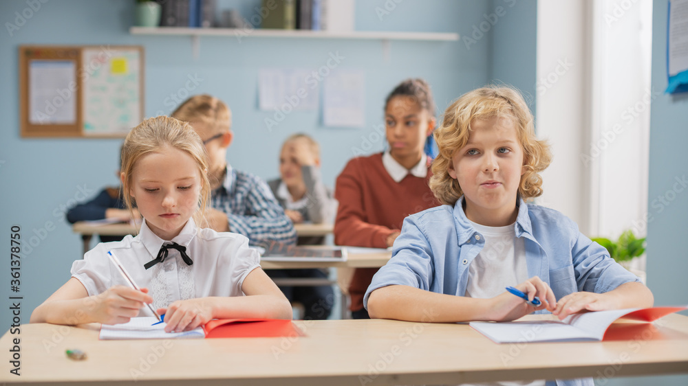 Elementary Classroom of Diverse Bright Children Listening Attentively to their Teacher Giving Lesson