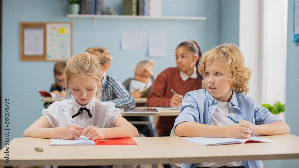 Elementary Classroom of Diverse Bright Children Listening Attentively to their Teacher Giving Lesson