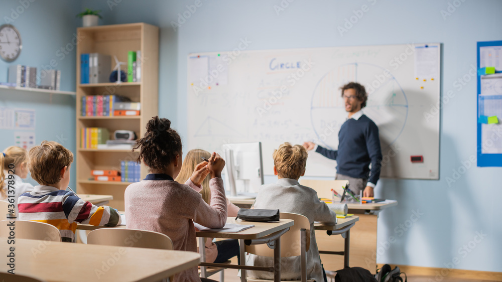 Caring Teacher Explains Lesson to a Classroom Full of Bright Diverse Children. In Elementary School 