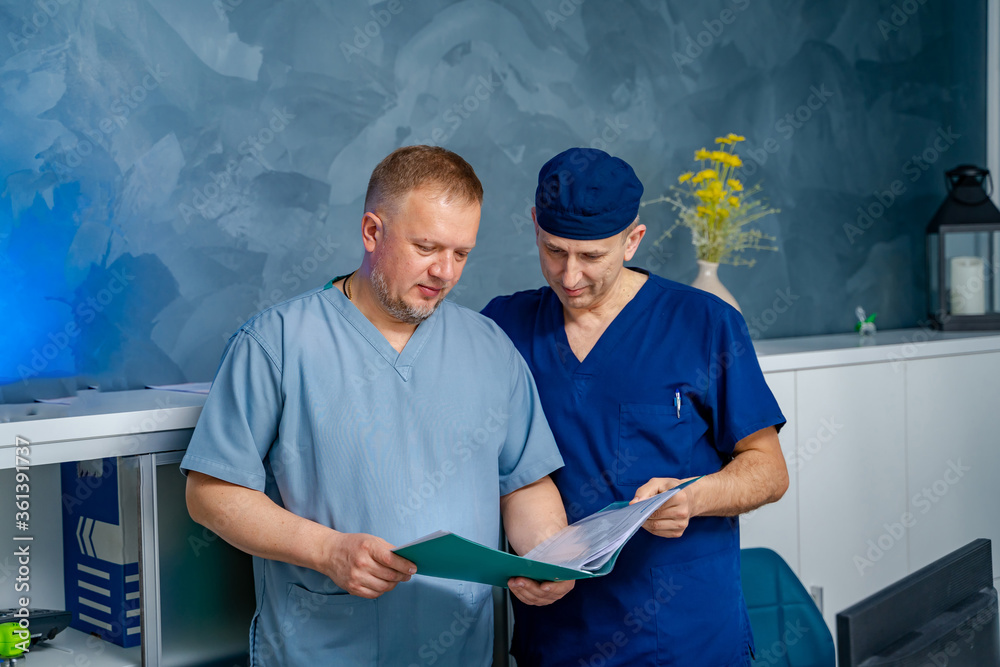 Two males doctor`s discussing diagnosis. Hospital office background.