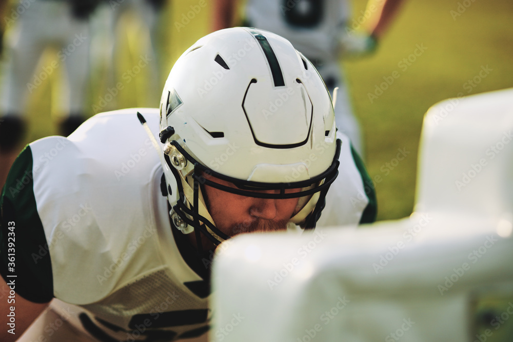 American football player doing practice tackles on a sports fiel