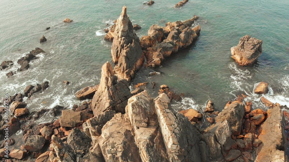 Aerial view rocks and stones on the Arambol beach in North Goa, India.