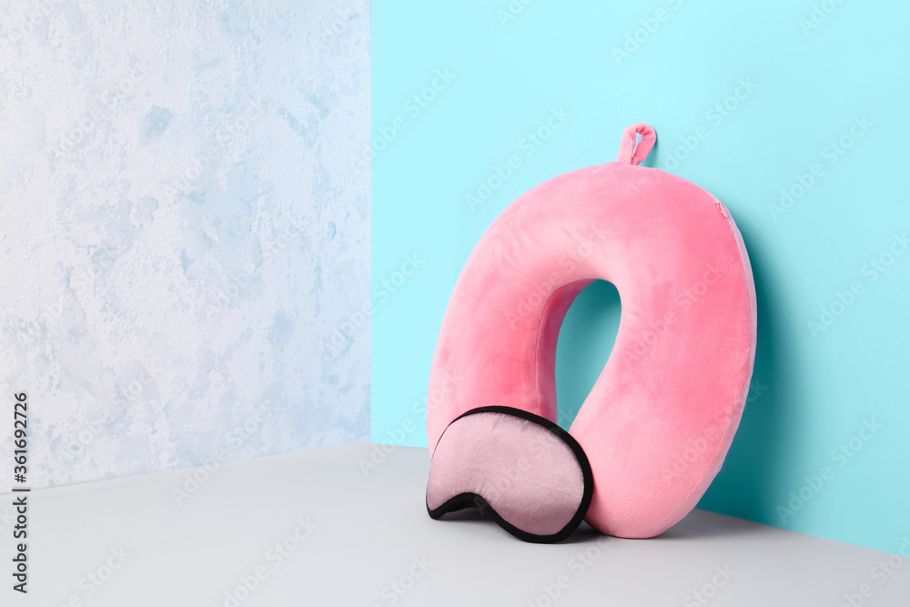 Travel pillow with sleep mask on color background